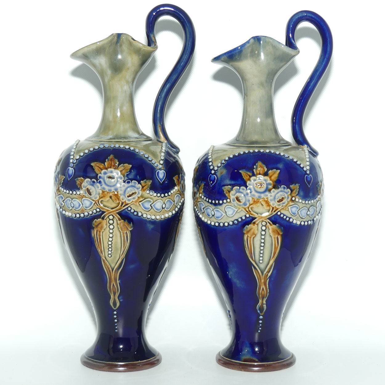 Royal Doulton pair of stoneware ewers with applied flowers, hearts and dots (stamped 7018)