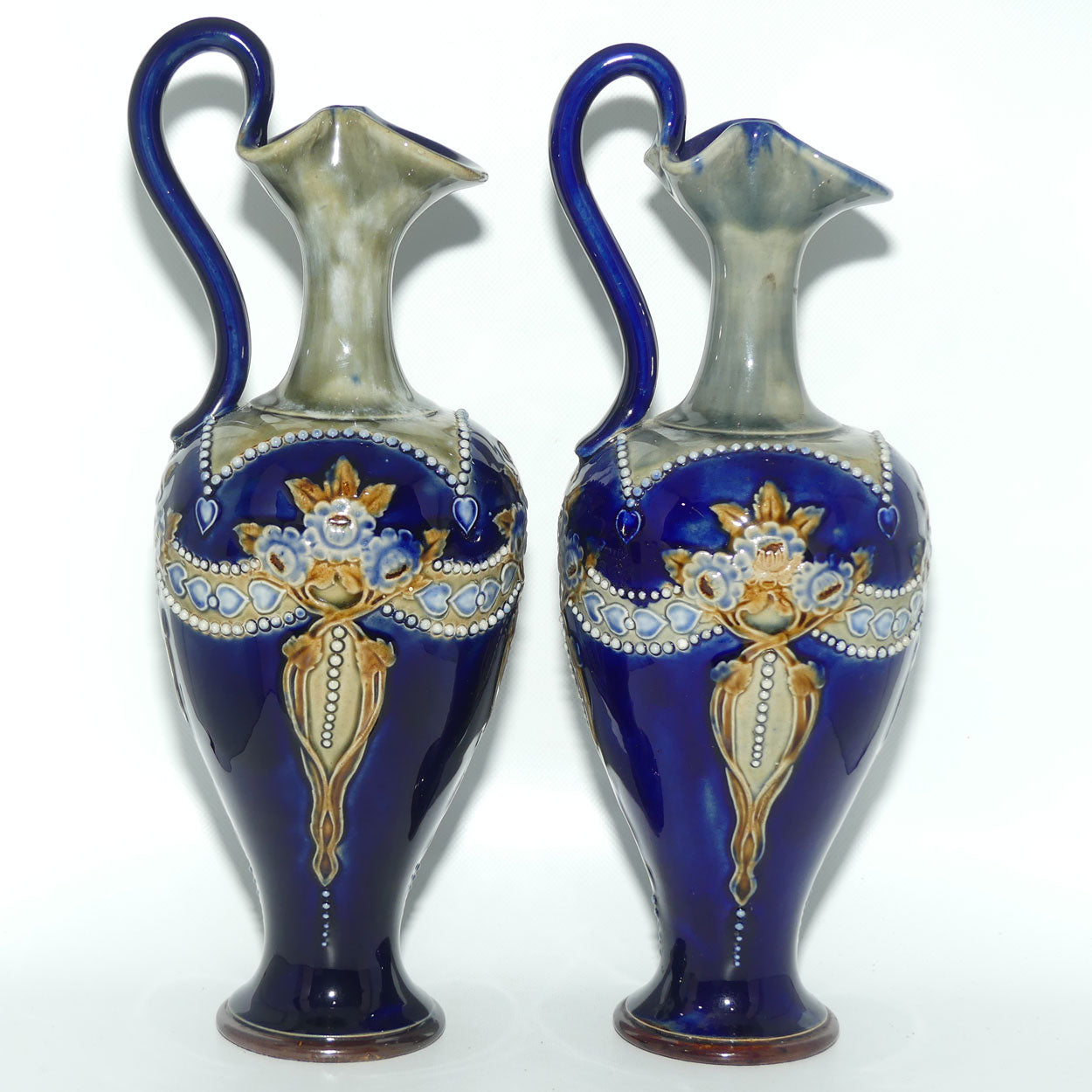 Royal Doulton pair of stoneware ewers with applied flowers, hearts and dots (stamped 7018)