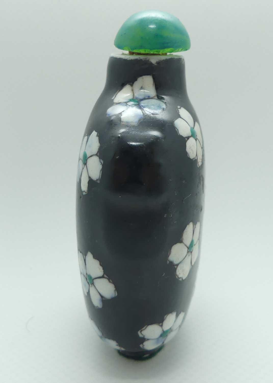 Chinese Black Ground and White Floral pattern Snuff Bottle | Green stone stopper