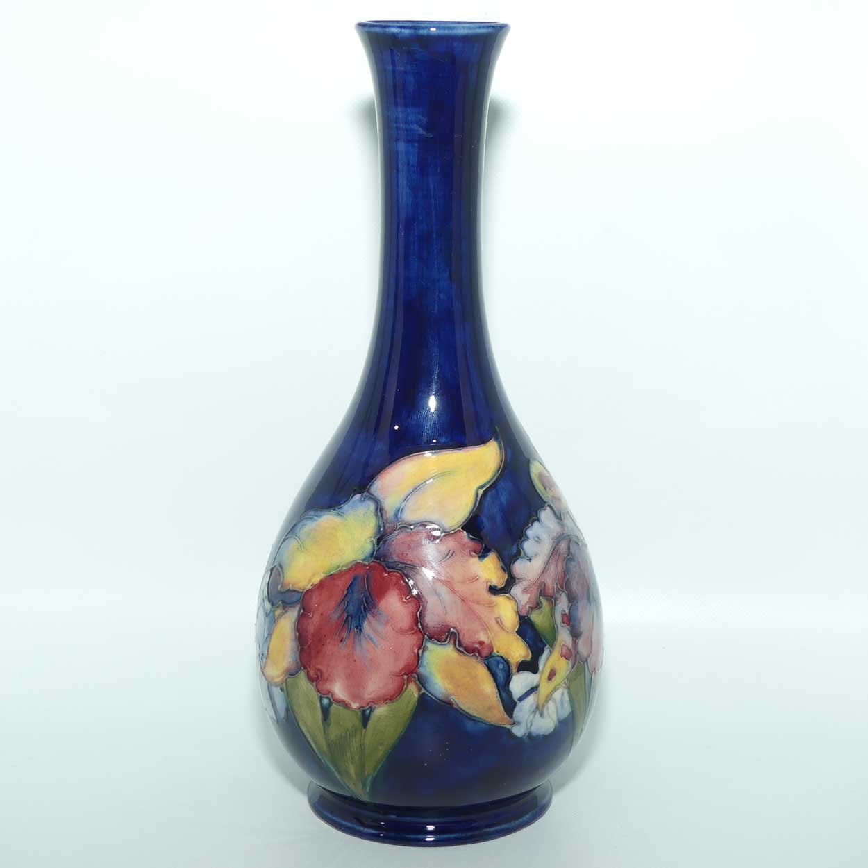 Walter Moorcroft Orchid on Dark Blue Ground tall narrow neck bottle vase