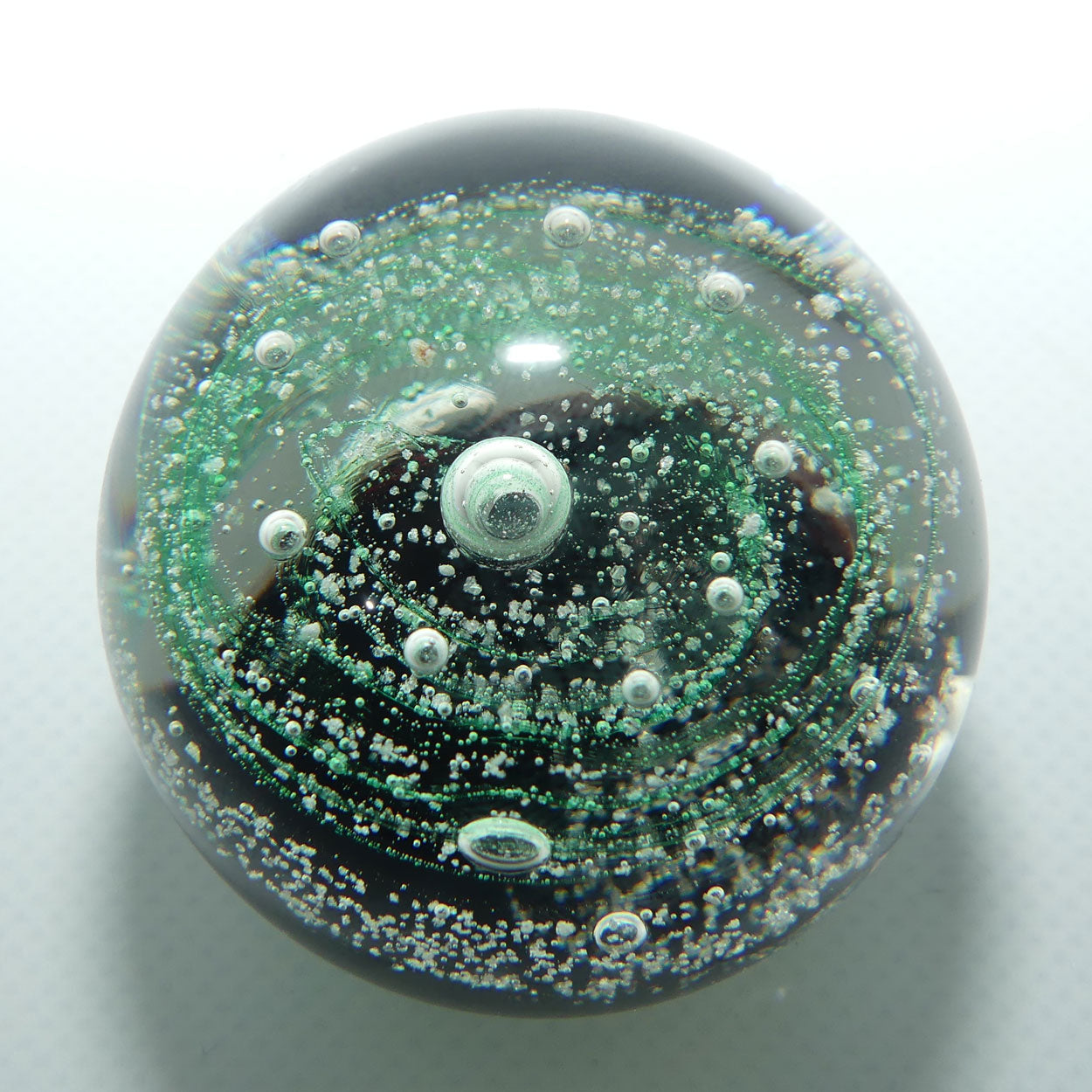 Controlled bubble within Green Swirl paperweight