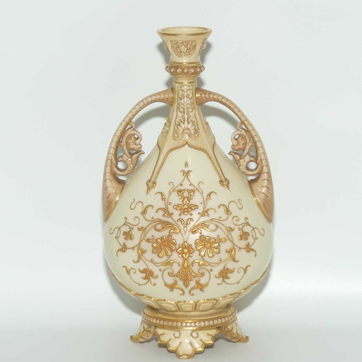 Royal Worcester Blush Ivory heavily gilt handled vase on quad feet