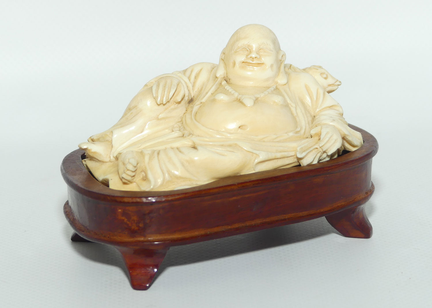 Elaborately carved Ivory Reclining Laughing Buddha on Wooden Stand | signed piece