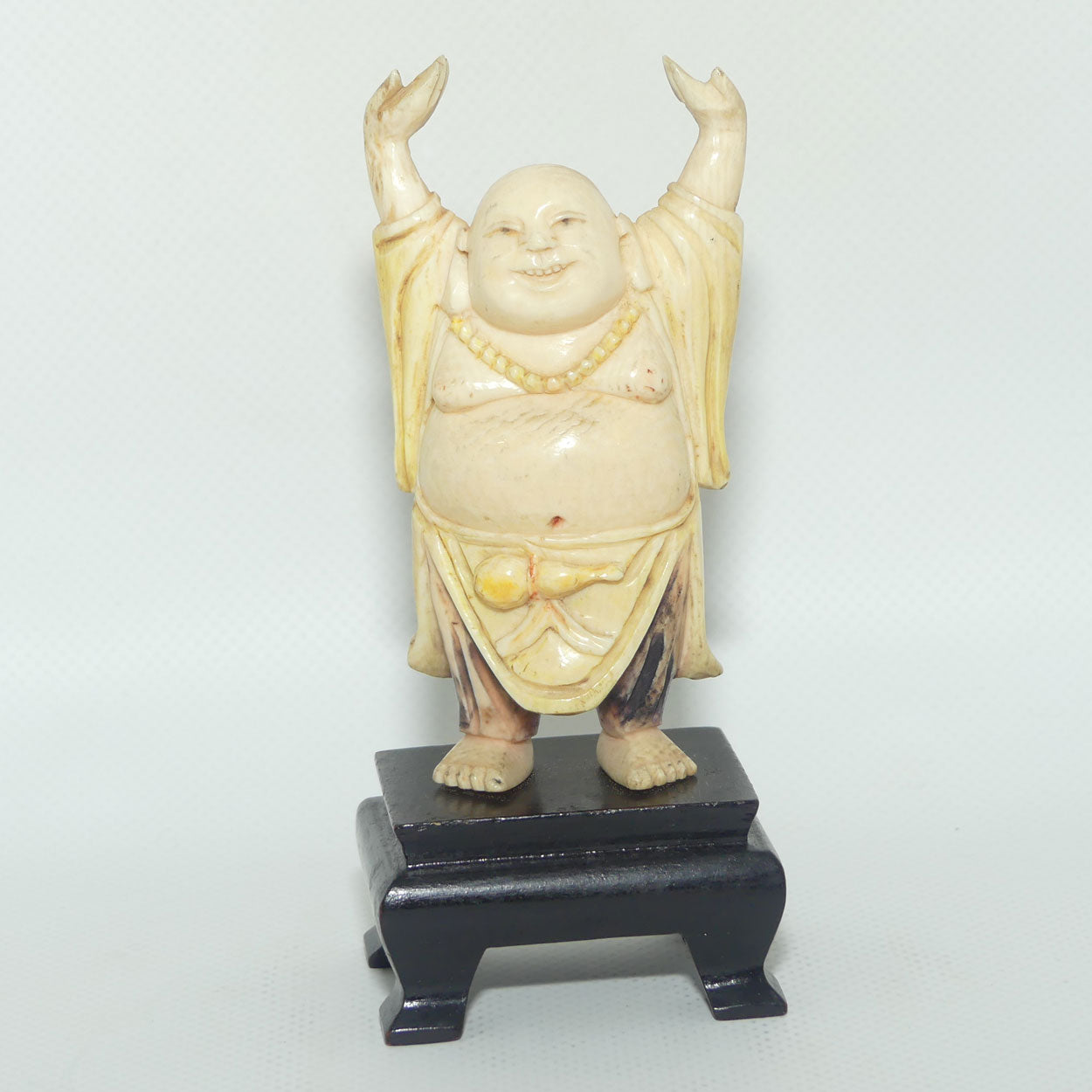 Beautifully carved Ivory Laughing Buddha with Both Hands Up on Wooden Stand