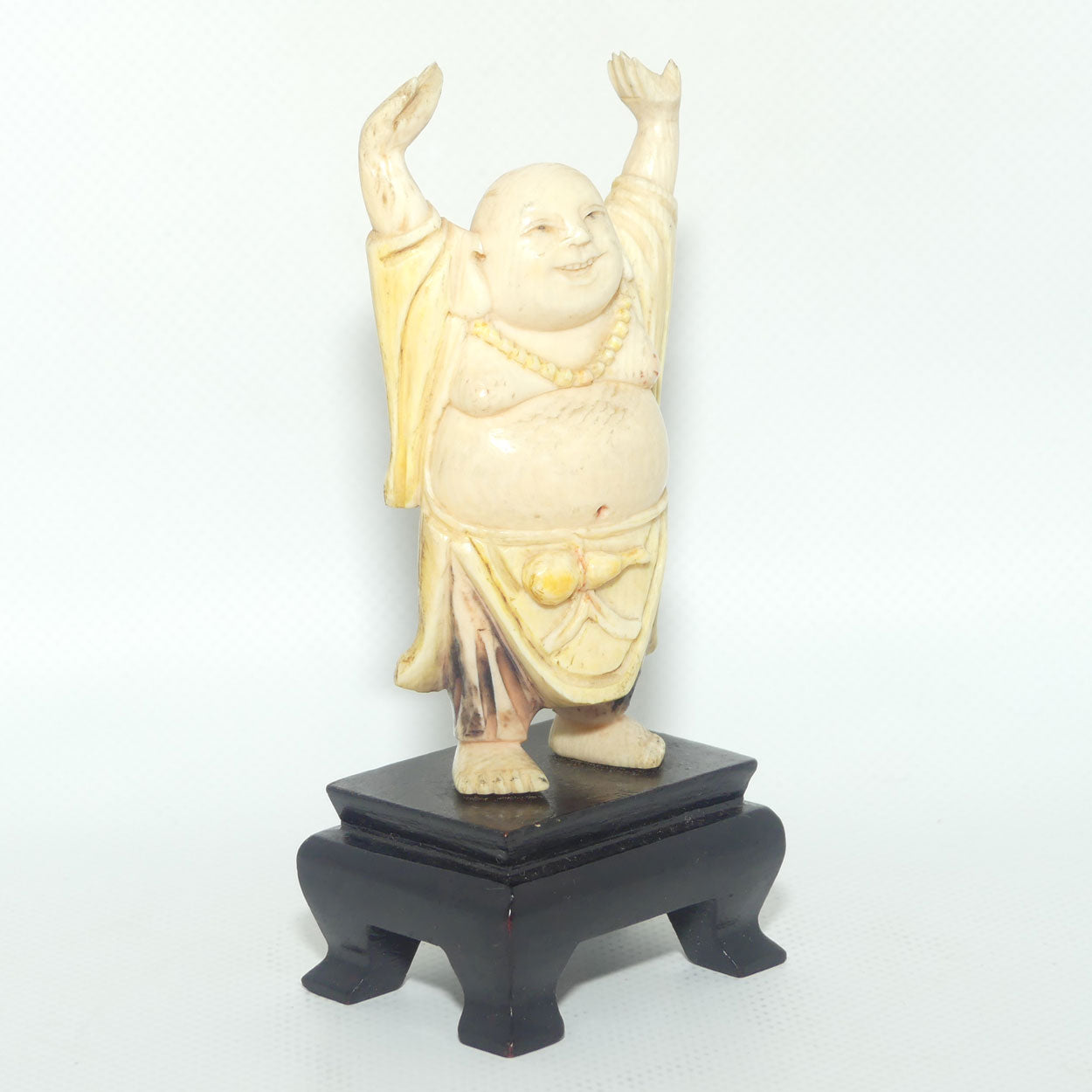 Beautifully carved Ivory Laughing Buddha with Both Hands Up on Wooden Stand