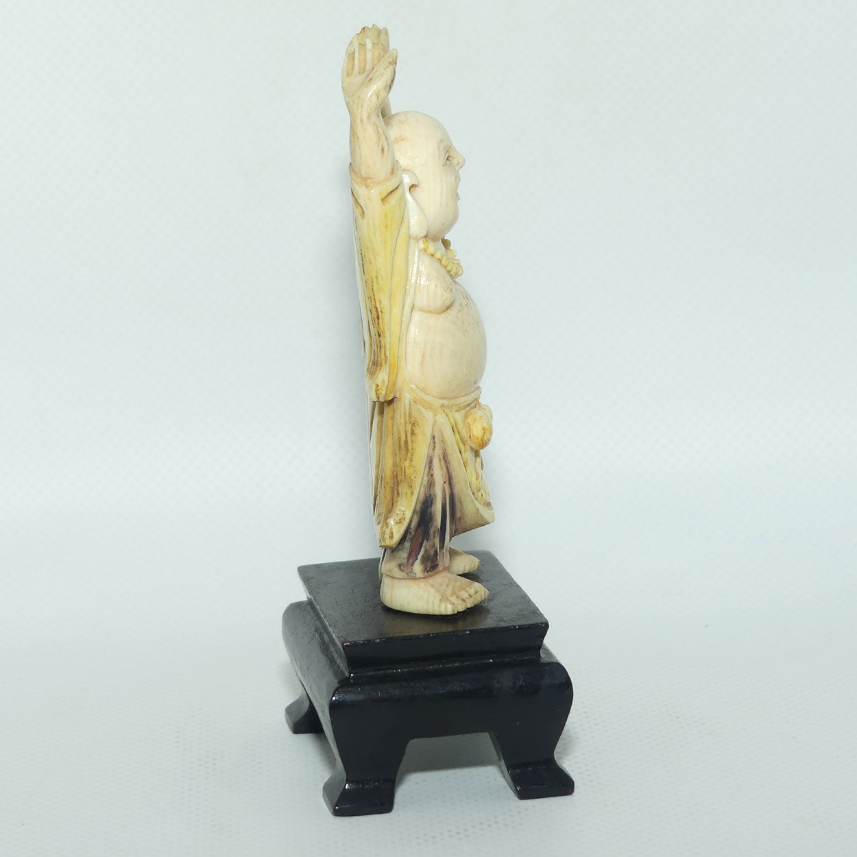 Beautifully carved Ivory Laughing Buddha with Both Hands Up on Wooden Stand