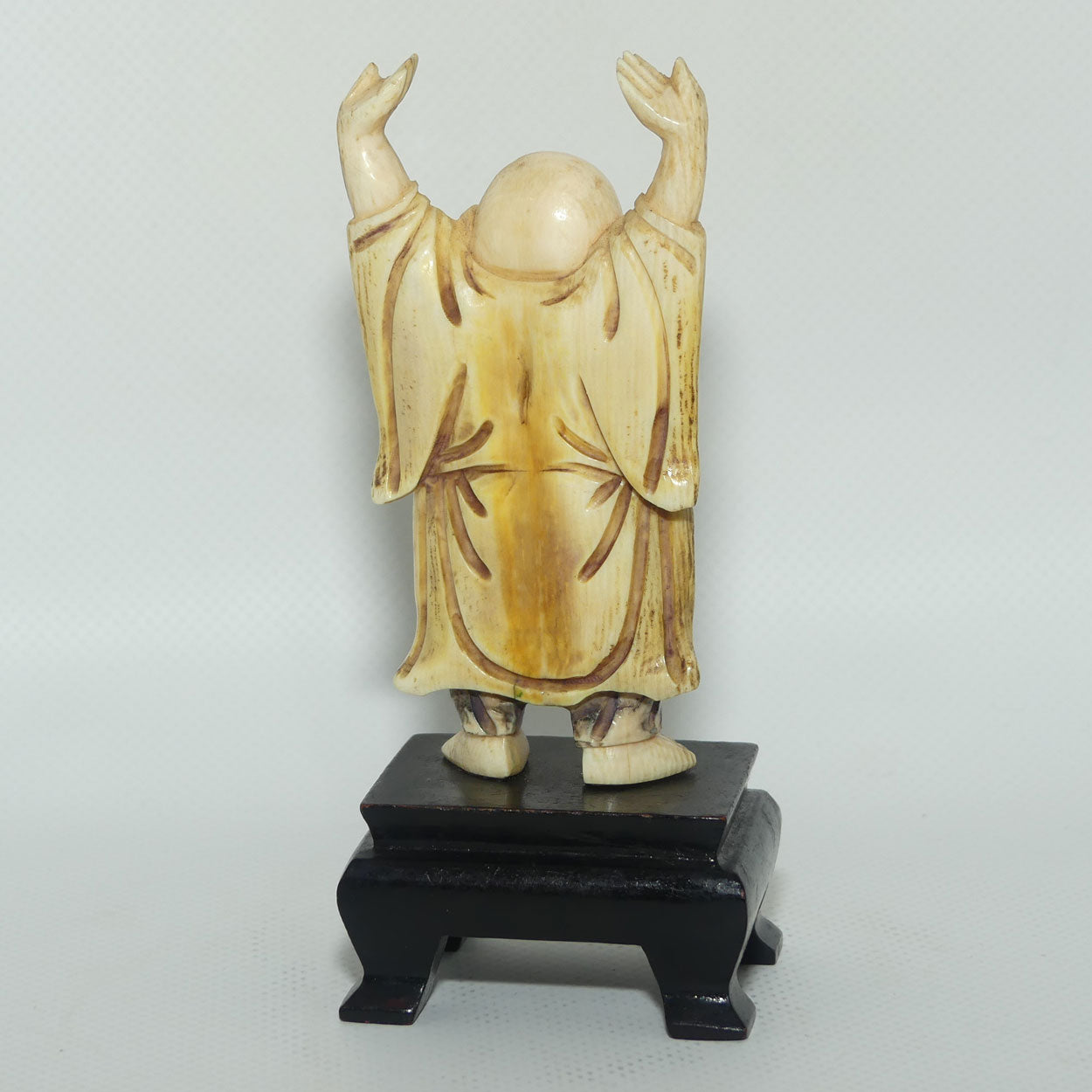Beautifully carved Ivory Laughing Buddha with Both Hands Up on Wooden Stand