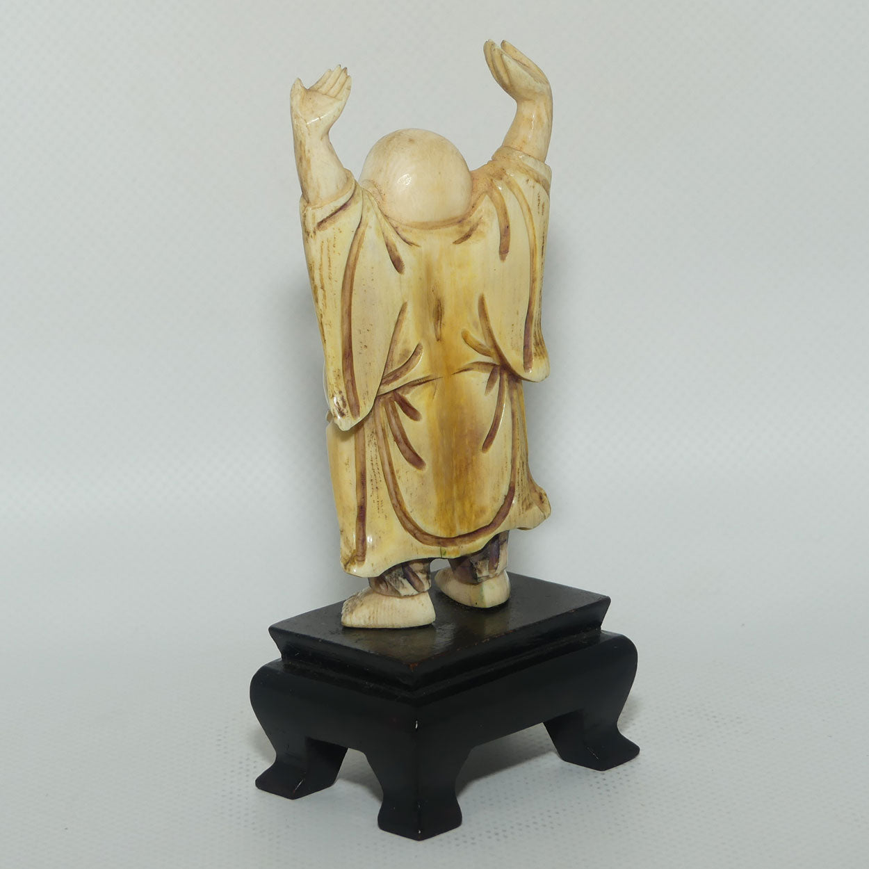 Beautifully carved Ivory Laughing Buddha with Both Hands Up on Wooden Stand