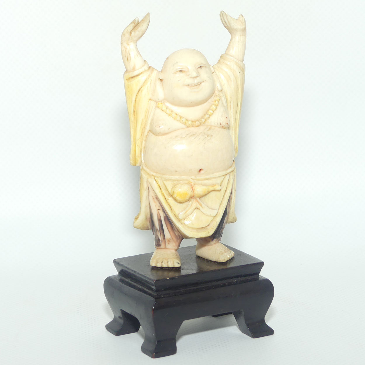 Beautifully carved Ivory Laughing Buddha with Both Hands Up on Wooden Stand