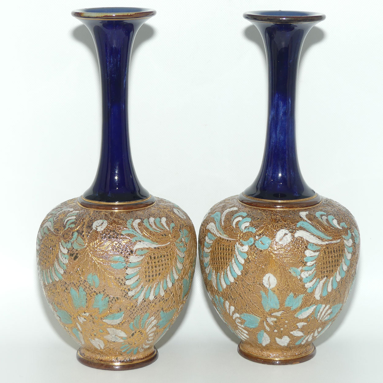 Doulton Slaters Pr of stoneware narrow neck vases with blue & white enamelling & gilt highlights (stamped 5098, painted X5094)