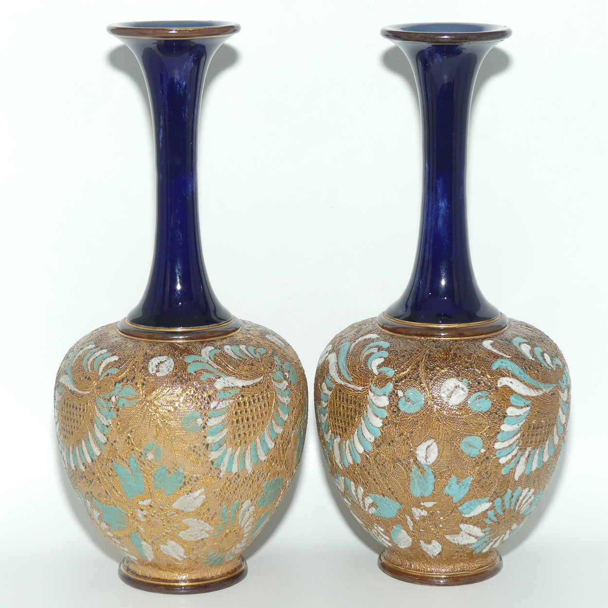 Doulton Slaters Pr of stoneware narrow neck vases with blue & white enamelling & gilt highlights (stamped 5098, painted X5094)
