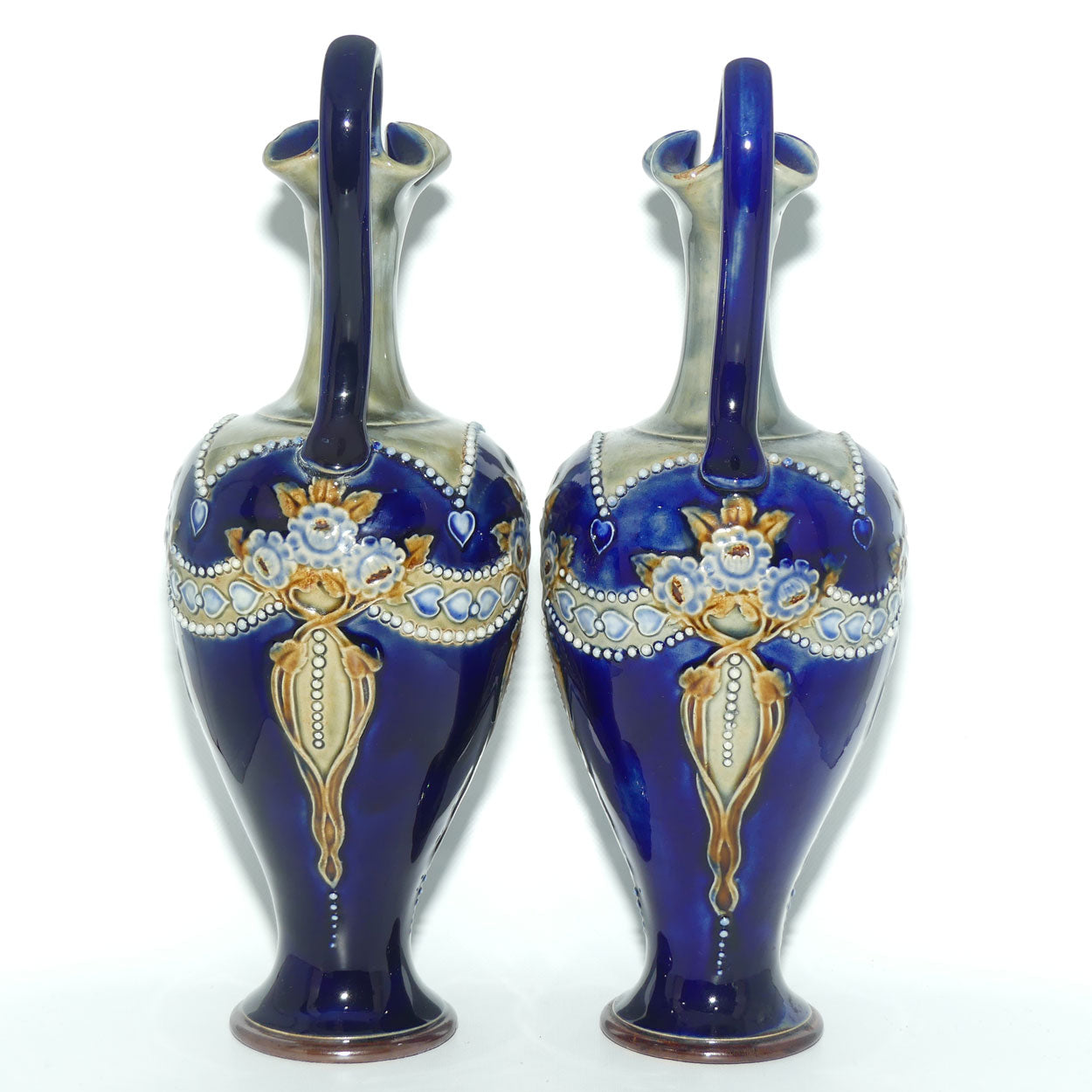 Royal Doulton pair of stoneware ewers with applied flowers, hearts and dots (stamped 7018)