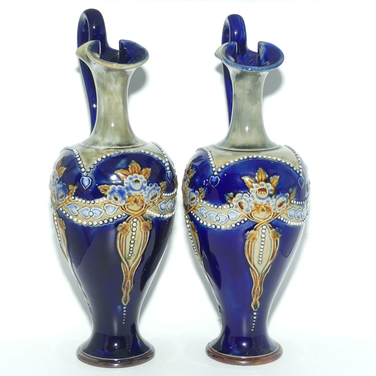 Royal Doulton pair of stoneware ewers with applied flowers, hearts and dots (stamped 7018)