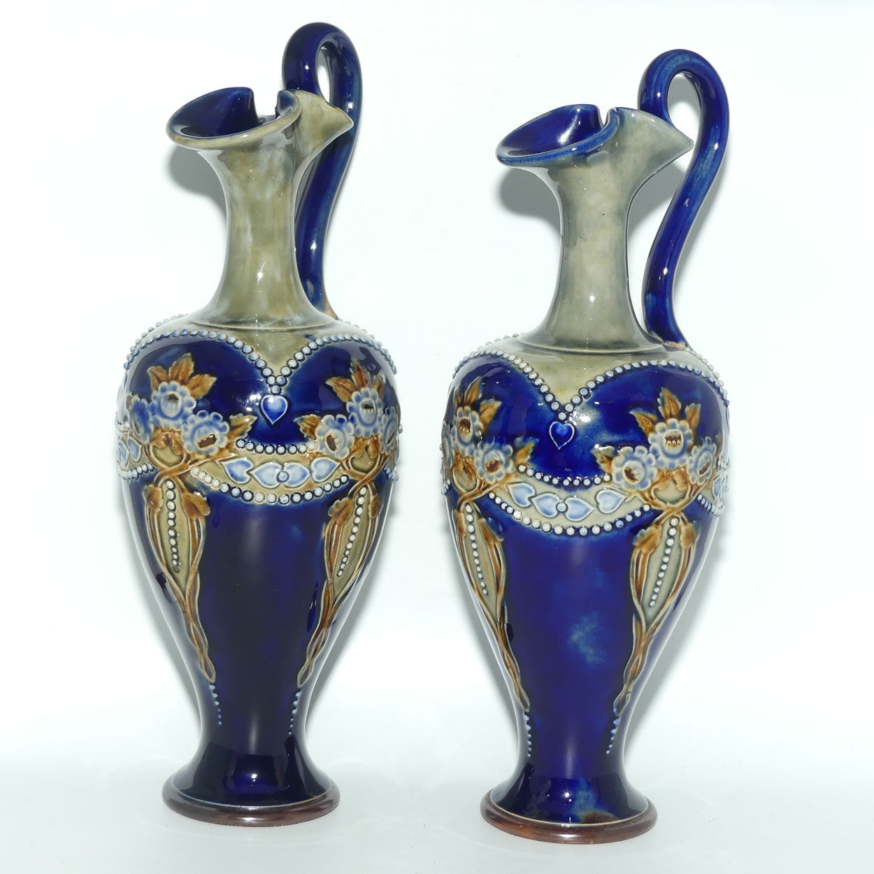 Royal Doulton pair of stoneware ewers with applied flowers, hearts and dots (stamped 7018)
