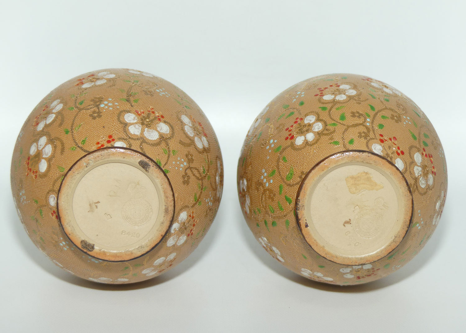 Royal Doulton pair of stoneware narrowneck bulbous vases with red, white & green enamelling and gilt highlights (stamped 8420)