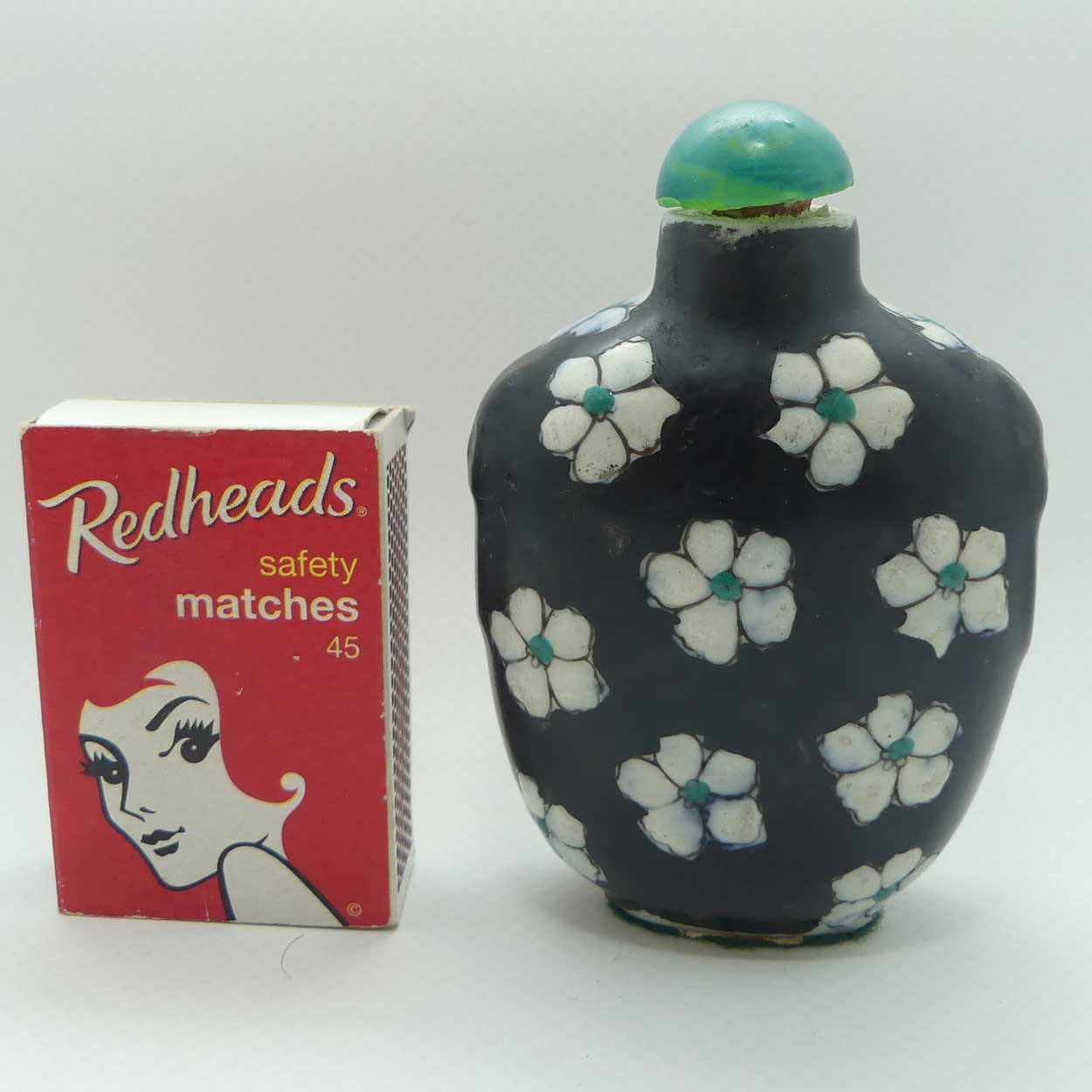 Chinese Black Ground and White Floral pattern Snuff Bottle | Green stone stopper