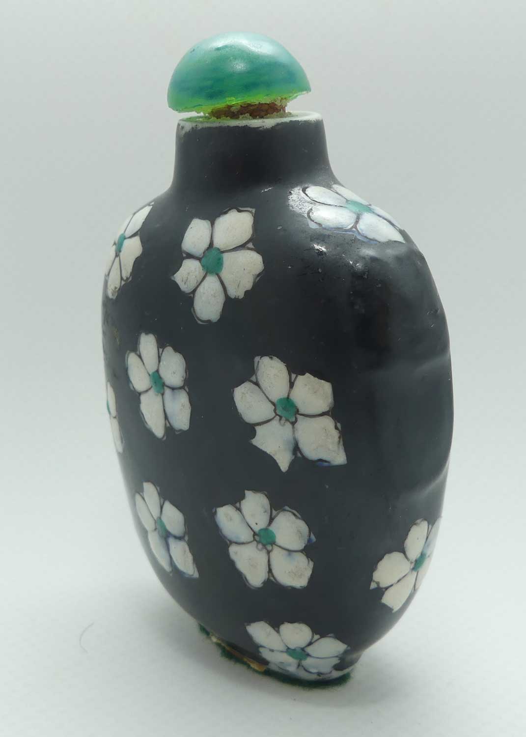 Chinese Black Ground and White Floral pattern Snuff Bottle | Green stone stopper