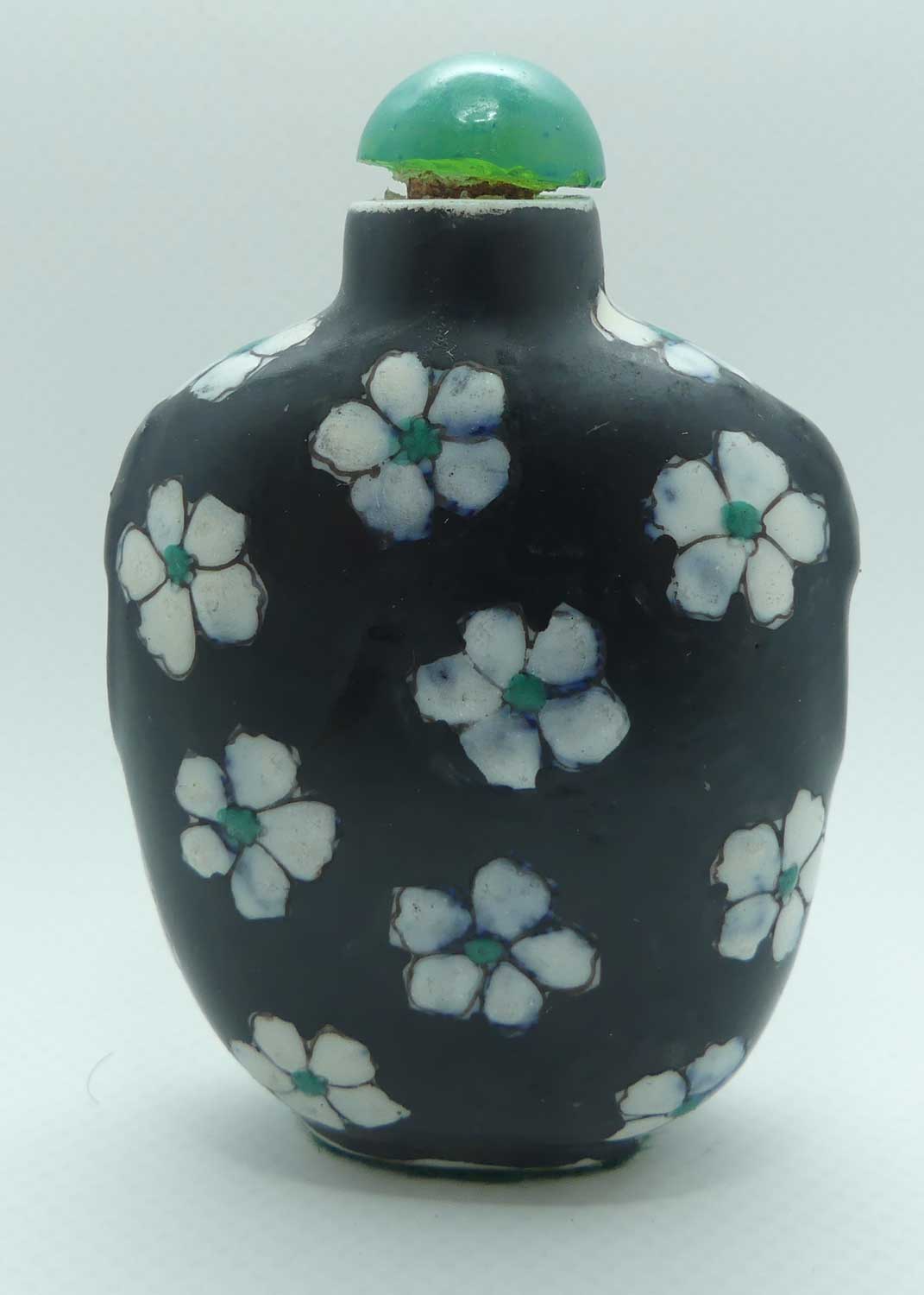 Chinese Black Ground and White Floral pattern Snuff Bottle | Green stone stopper