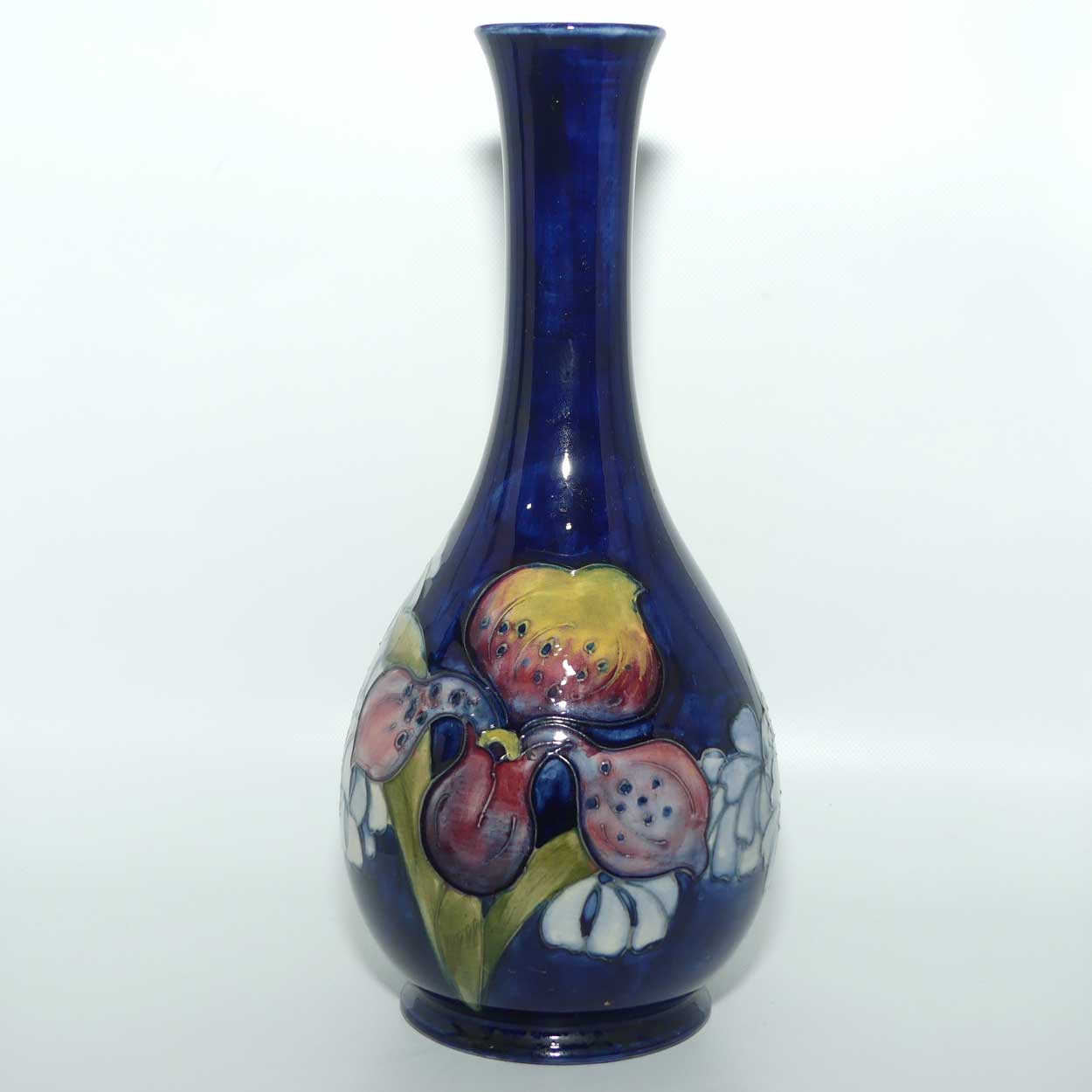 Walter Moorcroft Orchid on Dark Blue Ground tall narrow neck bottle vase