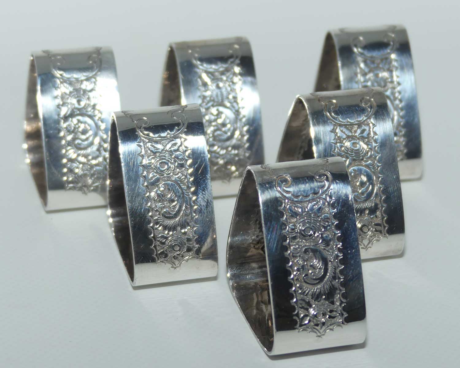 Edwardian era set of 6 Embossed triangular Silver plated napkin rings