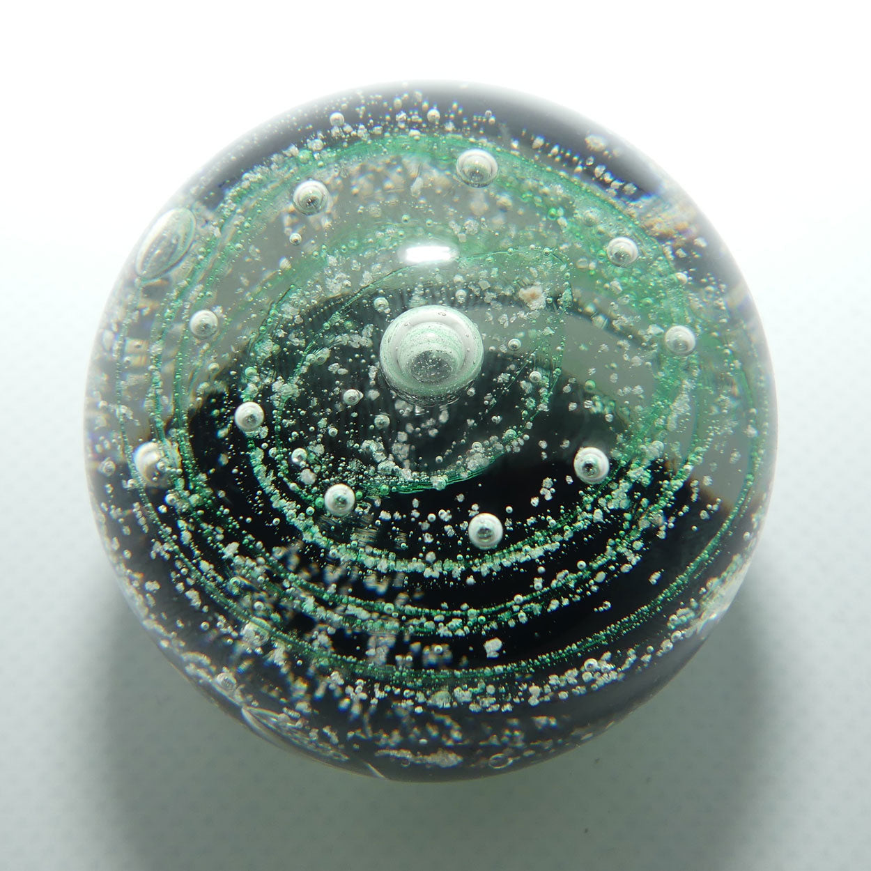 Controlled bubble within Green Swirl paperweight
