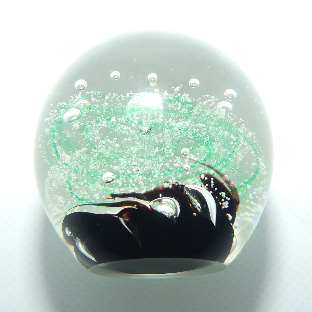 Controlled bubble within Green Swirl paperweight