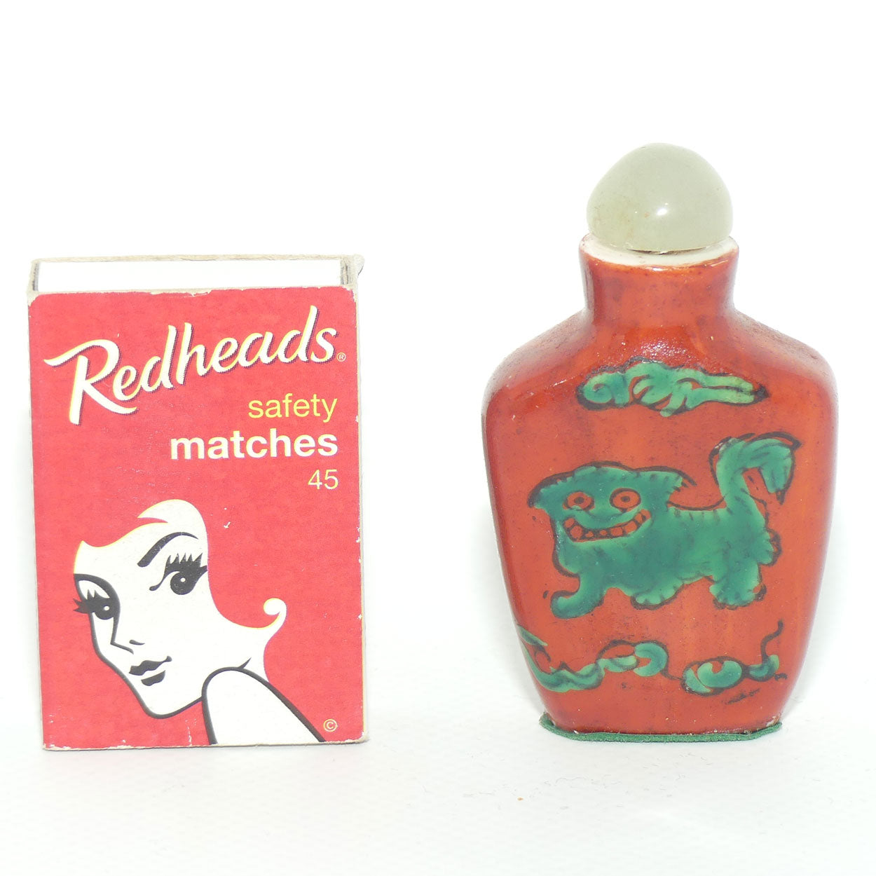 Chinese snuff bottle with greenstone stopper | Iron Red decorated with Dog of Fo