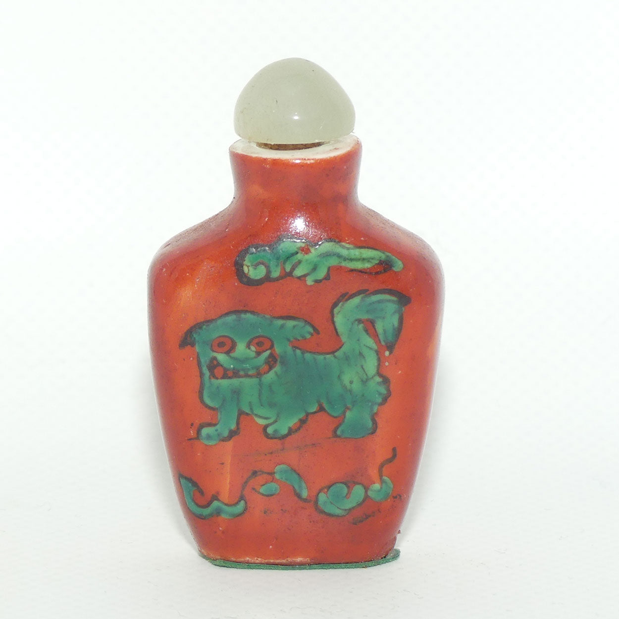 Chinese snuff bottle with greenstone stopper | Iron Red decorated with Dog of Fo