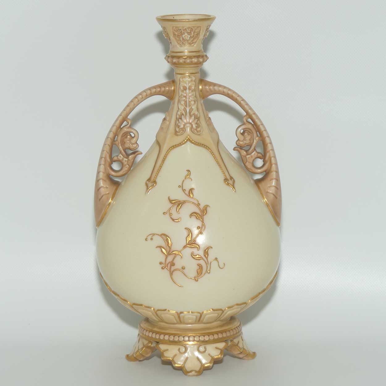 Royal Worcester Blush Ivory heavily gilt handled vase on quad feet