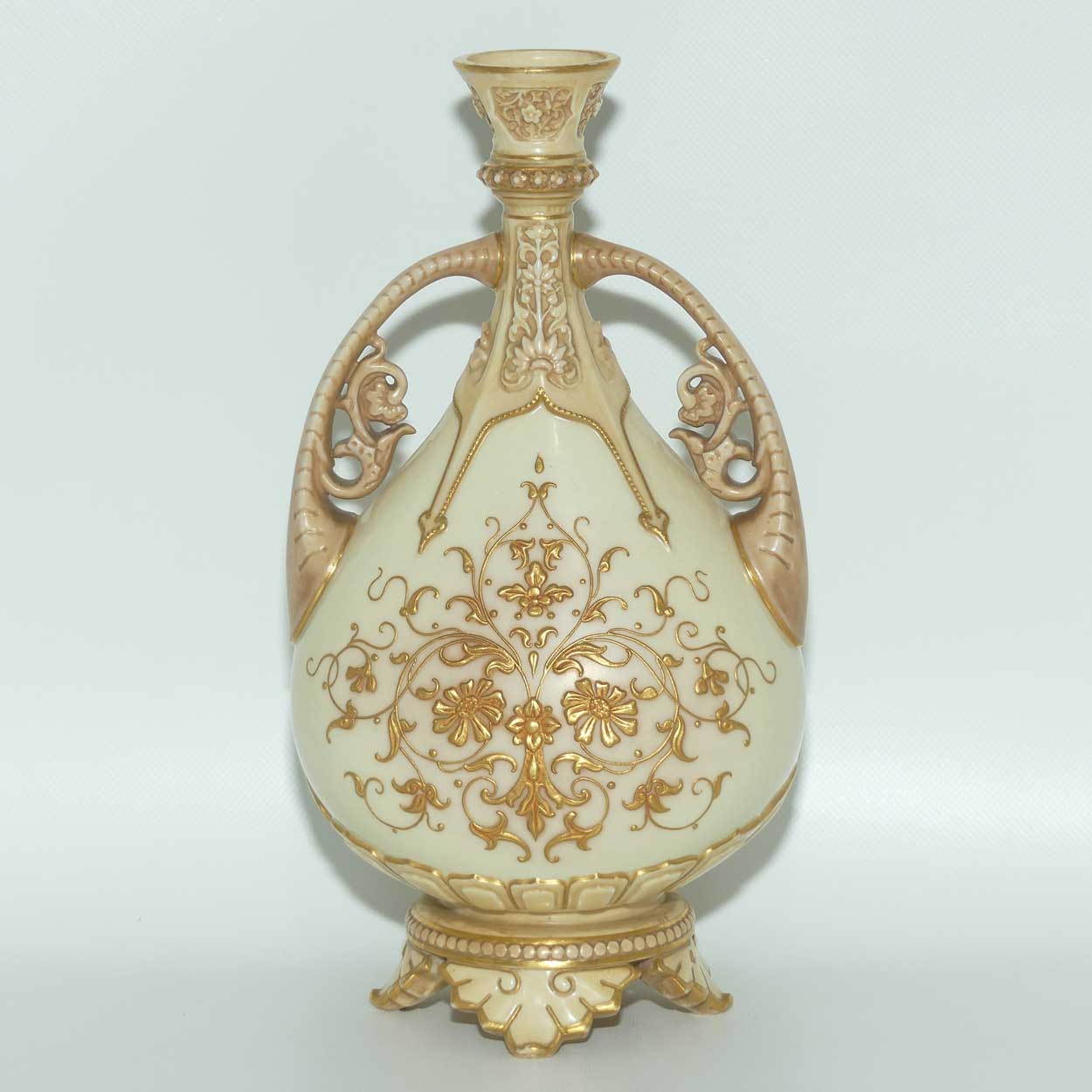Royal Worcester Blush Ivory heavily gilt handled vase on quad feet