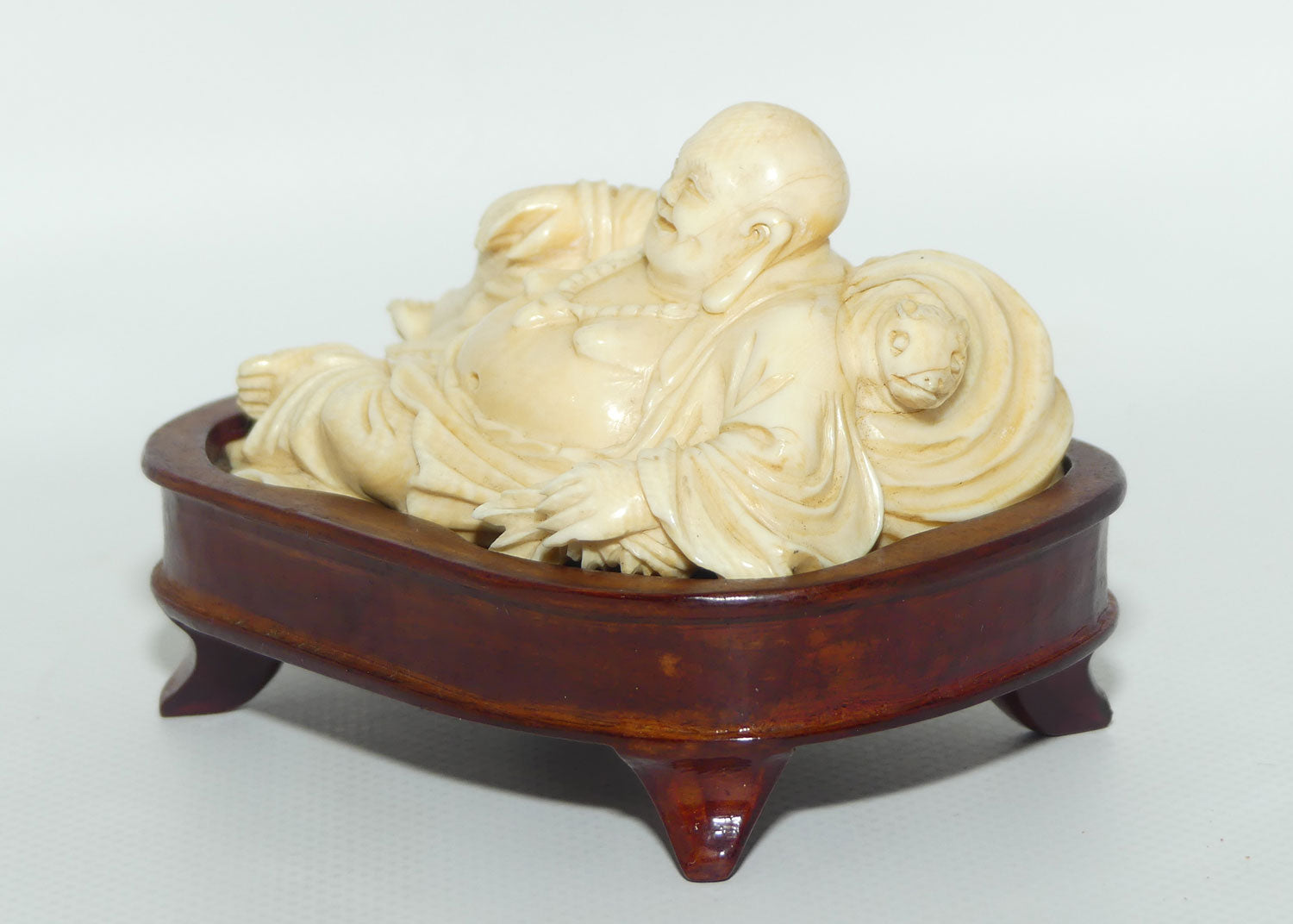 Elaborately carved Ivory Reclining Laughing Buddha on Wooden Stand | signed piece