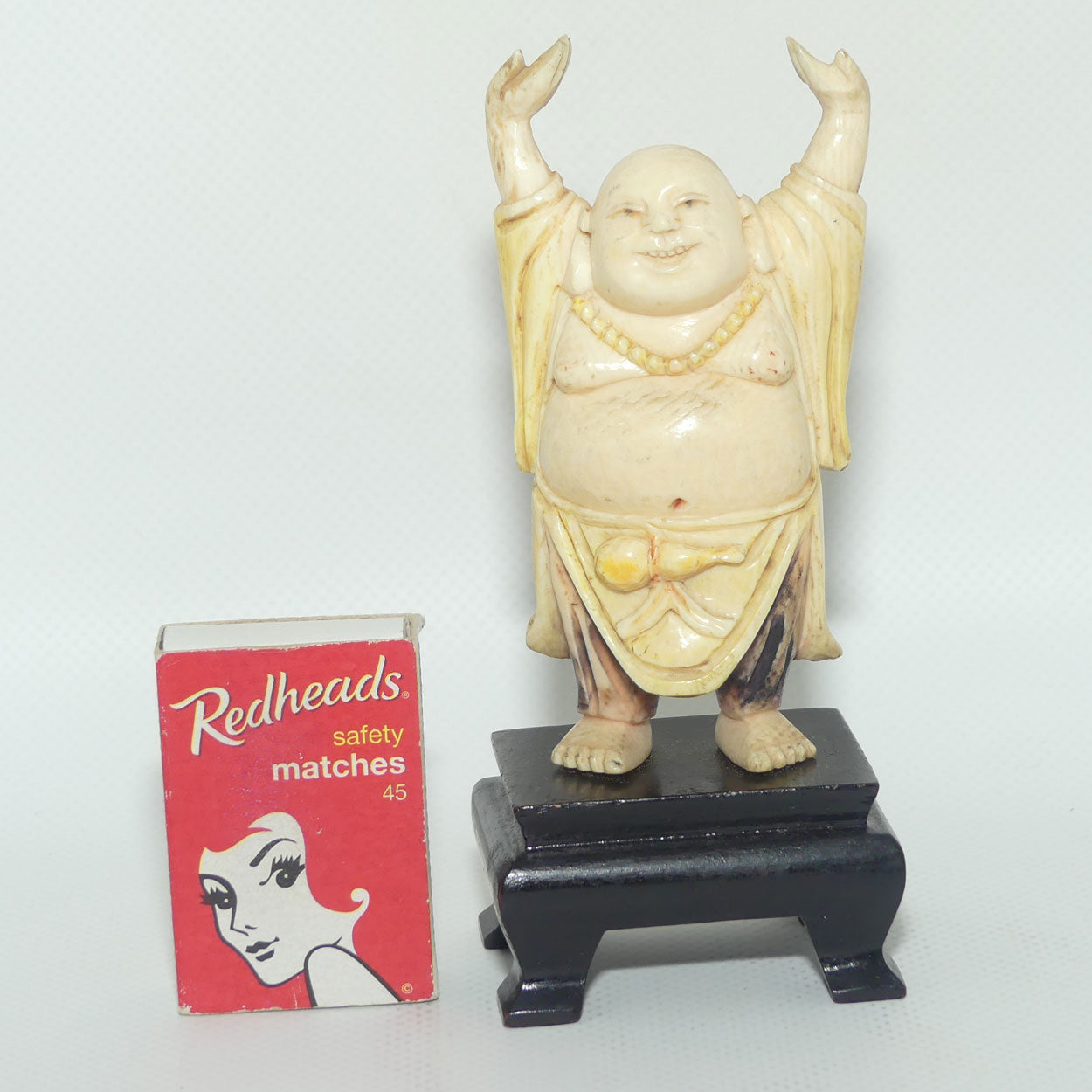 Beautifully carved Ivory Laughing Buddha with Both Hands Up on Wooden Stand