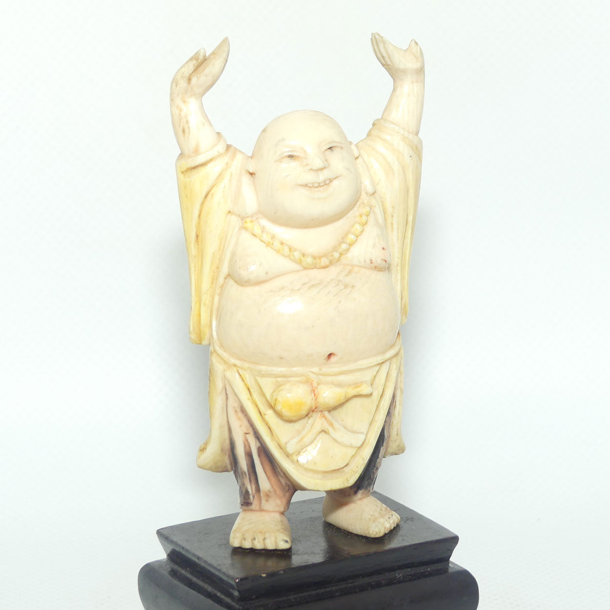 Beautifully carved Ivory Laughing Buddha with Both Hands Up on Wooden Stand