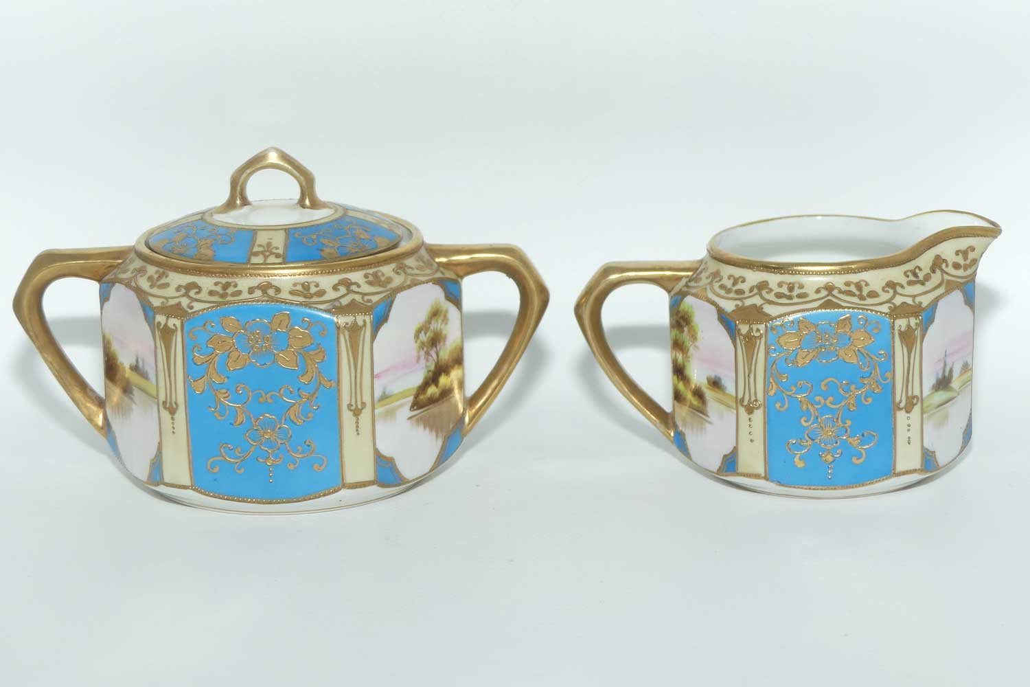 early Noritake Hand Painted and Gilt decorated Blue ground milk and sugar | Hexagonal shape | Lake Scene